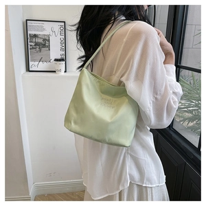 Detail of light green nylon hobo bag with 'pretty and liberty' embroidery and slim strap