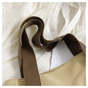 Close-up of thick canvas tote bag with reinforced brown handles and clean stitching