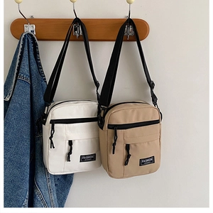 Close-up of canvas crossbody bags with adjustable straps in white and khaki colors