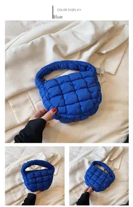 Detail view of blue quilted down handbag featuring puffer square stitching and zipper