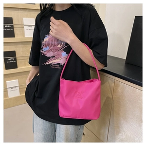 Detail shot of bright pink nylon tote bag featuring Pretty and liberty embossed text