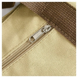 Close-up of durable metal zipper and reinforced stitching on the canvas tote bag