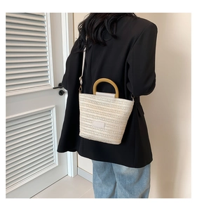 Vue détaillée du sac seau tissé avec poignées rondes en bois et texture beige