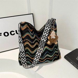 Colorful striped woven velvet tote bag with wide geometric strap and plush pendant
