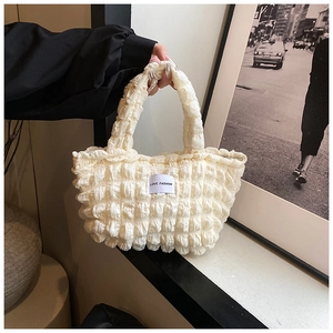 Détail de la texture bulle crème et étiquette LOVE FASHION sur un sac à main chic