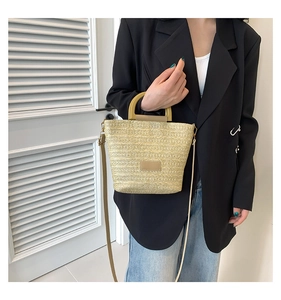 Vue détaillée d'un sac en paille tressée avec poignée en bois en U et bandoulière réglable