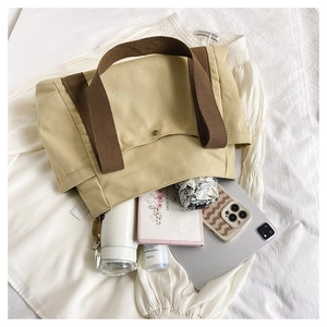 Macro view of beige canvas tote bag interior showing large capacity and snap button closure