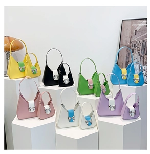 Collection of minimalist bow-tie saddle bags in various colors on geometric stands