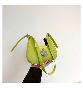 Détail du sac à main demi-lune vert avec sa boucle magnétique en métal en forme de fleur