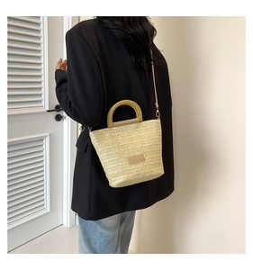 Détail du sac cabas tissé main avec texture beige naturelle et poignées rigides en U