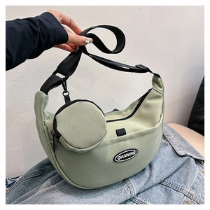 Detail of light green nylon hobo bag with round coin purse and QIANNING logo patch