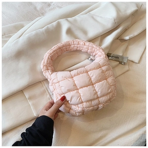 Detail view of pink quilted puffer handbag showing soft grid texture and zipper closure