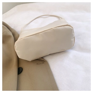 Chic beige nylon shoulder bag displayed on a blazer for a minimalist Korean style look