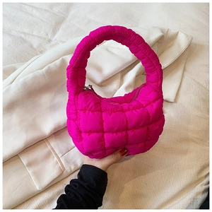 Detailed close-up of pink quilted puffer handbag with cloud-like puffy texture