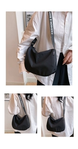 Detail of black nylon half-moon crossbody bag with wide logo strap and fashion lettering