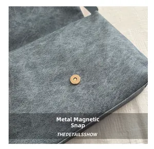 Détail de la fermeture magnétique dorée sur le sac en daim givré gris pour femme