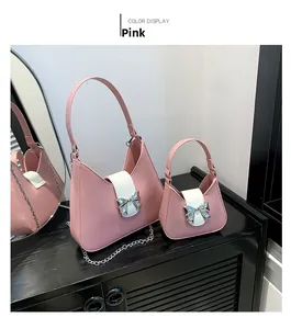 Pink saddle bag with white flap and silver bow detail in two sizes with metal chains