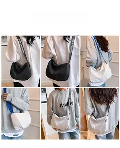 Detailed views of minimalist canvas crossbody bags in black and white with wide logo straps