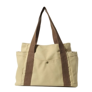 Large beige canvas tote bag with brown straps and functional pockets for daily commute