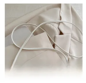 Detail of soft white leather shoulder strap on a minimalist crossbody square bag