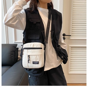Detail of off-white utility crossbody bag showing nylon texture and fashion label
