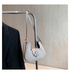 Détail du sac demi-lune blanc crème avec élégante boucle fleurie en métal argenté