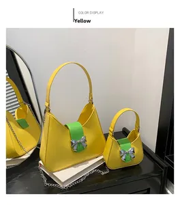 Detail of yellow saddle bag set with green flap and silver bow clasp accessory