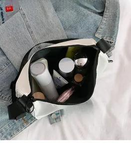 Top view of large capacity white canvas bag interior with cosmetics and nylon strap