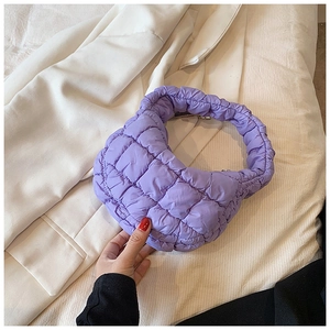 Macro shot of purple quilted puffer bag material and stitched square pattern detail
