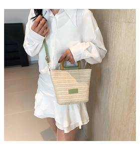 Détail du sac seau tissé pour femme avec garniture en cuir vert et poignée en bois