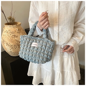 Détail du sac plissé bleu clair avec texture bulle et étiquette tissée LOVE FASHION