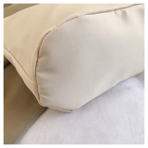 Detail of reinforced base and durable nylon fabric texture on a cream tote bag