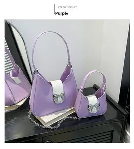 Purple leather saddle bag set with white flap, silver bow clasp, and metal chain detail
