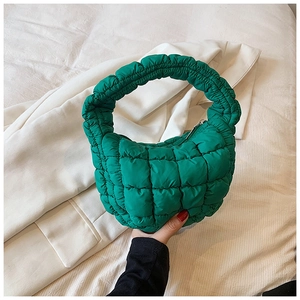 Close-up of vibrant green quilted puffy cloud handbag with zipper and texture detail