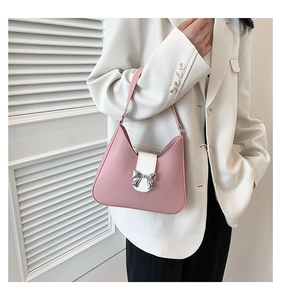 Detail of pink and white saddle bag with a decorative silver metal bow buckle