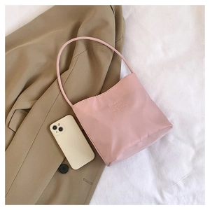 Pink nylon tote bag detail featuring delicate 'pretty and liberty' embroidery on matte fabric