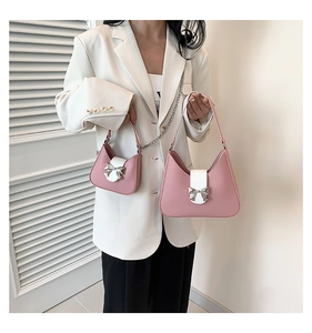Detail showing two sizes of pink saddle bags with white flap and silver bow buckle
