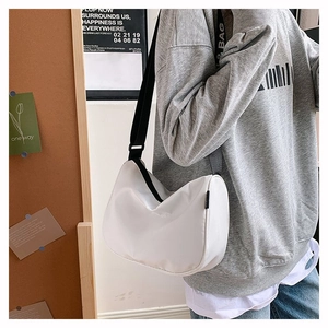 Detail of white nylon crescent bag showing the adjustable black strap with BAG text