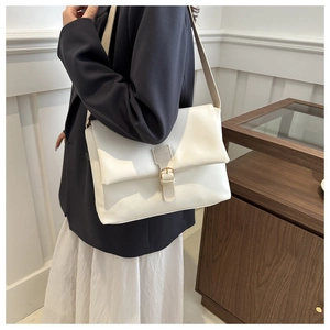 Détail du sac à bandoulière blanc avec boucle magnétique et bandoulière réglable