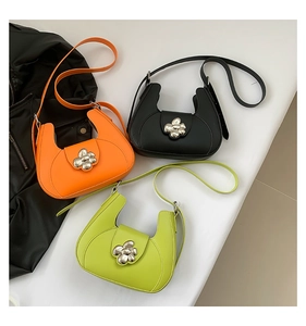 Détails des sacs à bandoulière en cuir orange, noir et vert avec boucles à fleurs