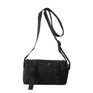 Minimalist black functional cylinder crossbody bag with adjustable straps and buckles