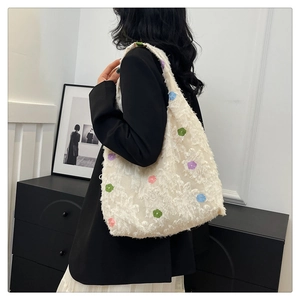 Detail view of the plush floral tote bag texture and colorful 3D flower decorations