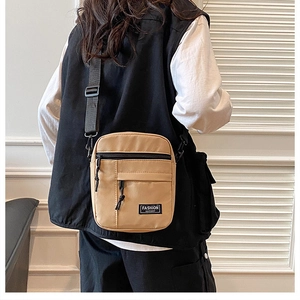 Detail of khaki nylon mini crossbody bag showing functional pockets and woven shoulder strap