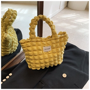 Détail de la texture jaune gaufrée et de l'étiquette Love Fashion sur le sac bouffant