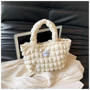 Détail du sac à main blanc crème à texture bulles avec étiquette tissée mode