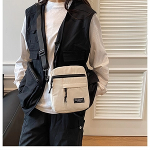 Close-up of beige nylon crossbody phone bag with multi-pocket design and adjustable strap