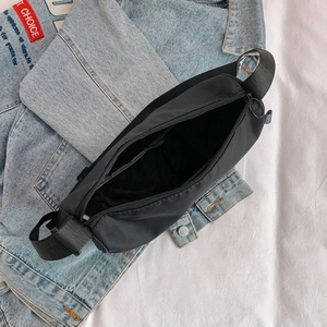 Internal view of a black canvas shoulder bag with zipper opening and spacious interior