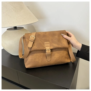 Gros plan sur le sac vintage marron givré avec bandoulière réglable et détail de boucle