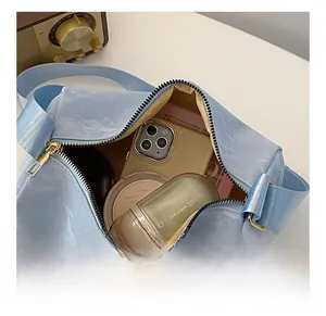 Detail view of light blue barrel bag interior showing space for phone and makeup