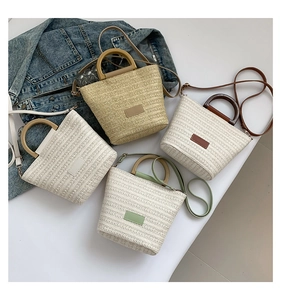 Détail de quatre sacs seaux en paille tressée avec diverses anses et bandoulières en cuir